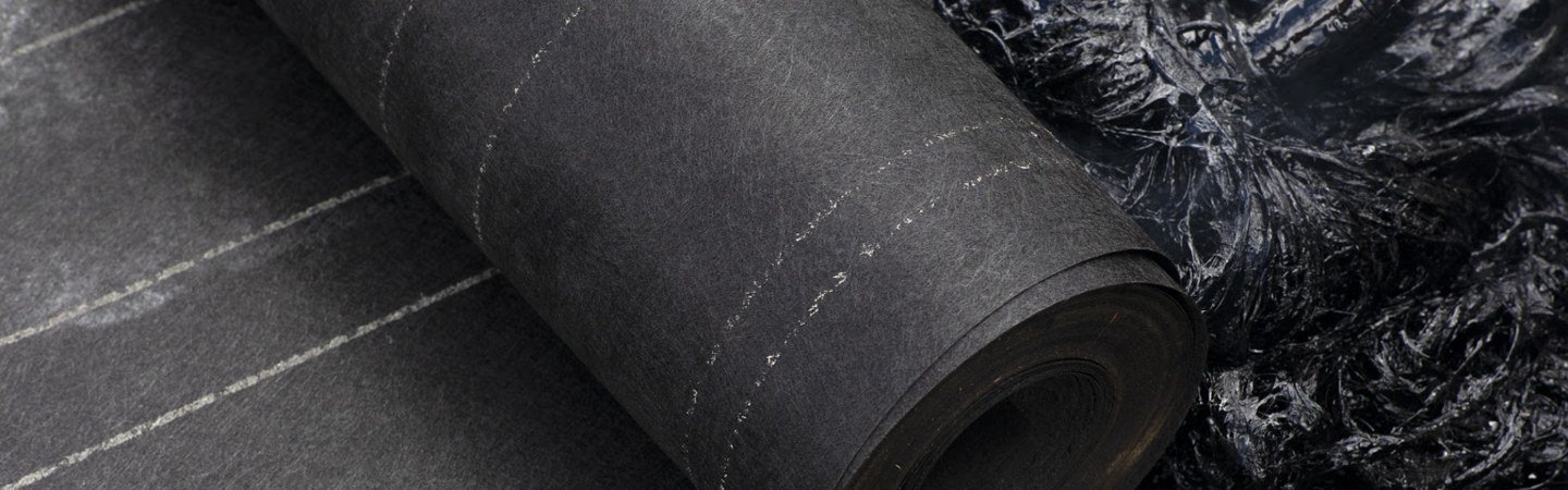 Close-up of reinforcing roofing felt being installed with bitumen in a built-up roof assembly