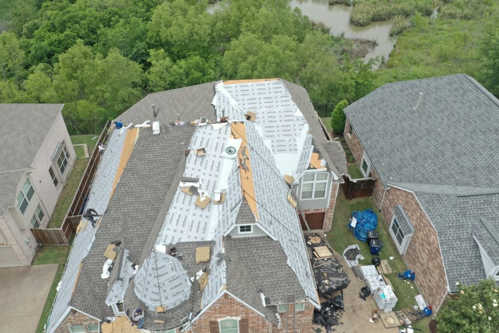Aerial drone view of a Roofing Giant roof replacement in progress with synthetic underlayment installed