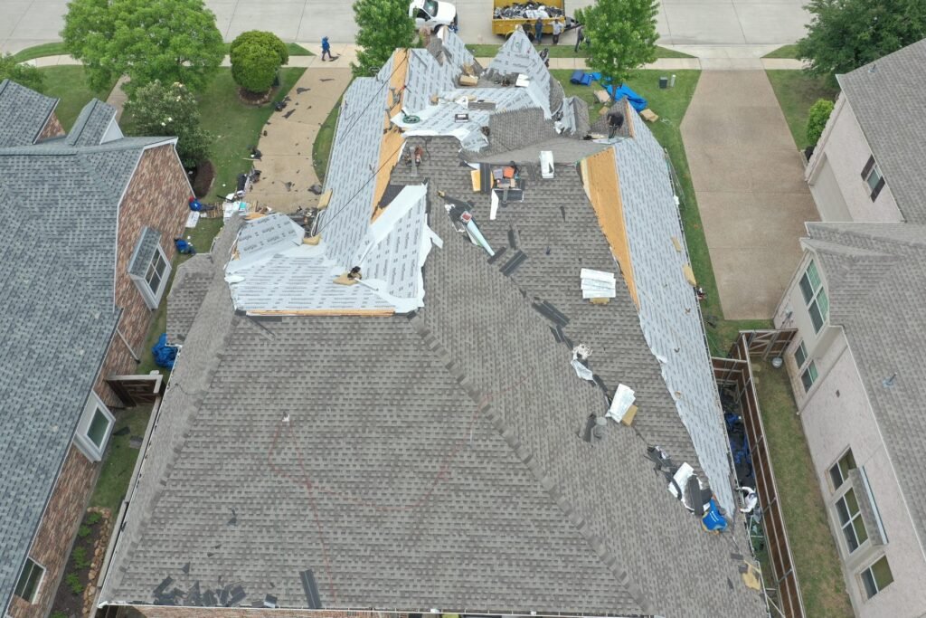Drone view of a roof tear-off and underlayment stage on a Dallas-Fort Worth home