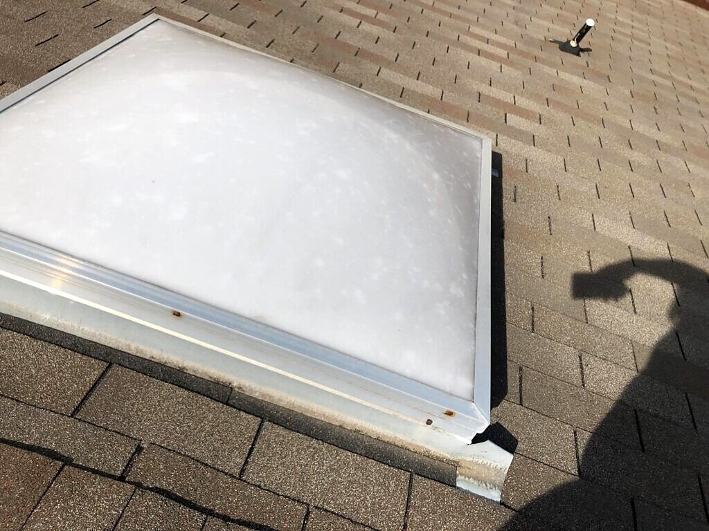 April 2019. The existing skylight lens and surrounding shingles.