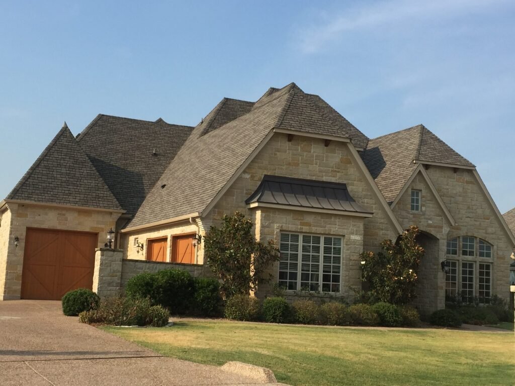Completed architectural shingle roof on a stone and brick home in Dallas-Fort Worth