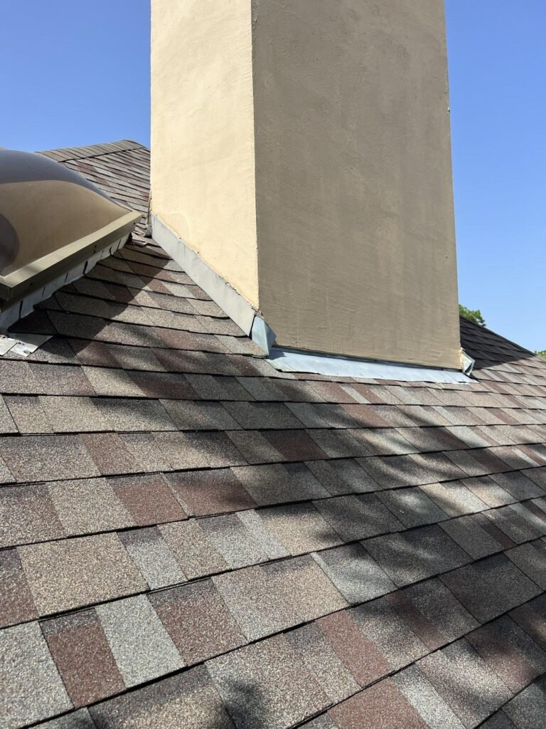 June 2022. Shingles and flashing at the chimney base.