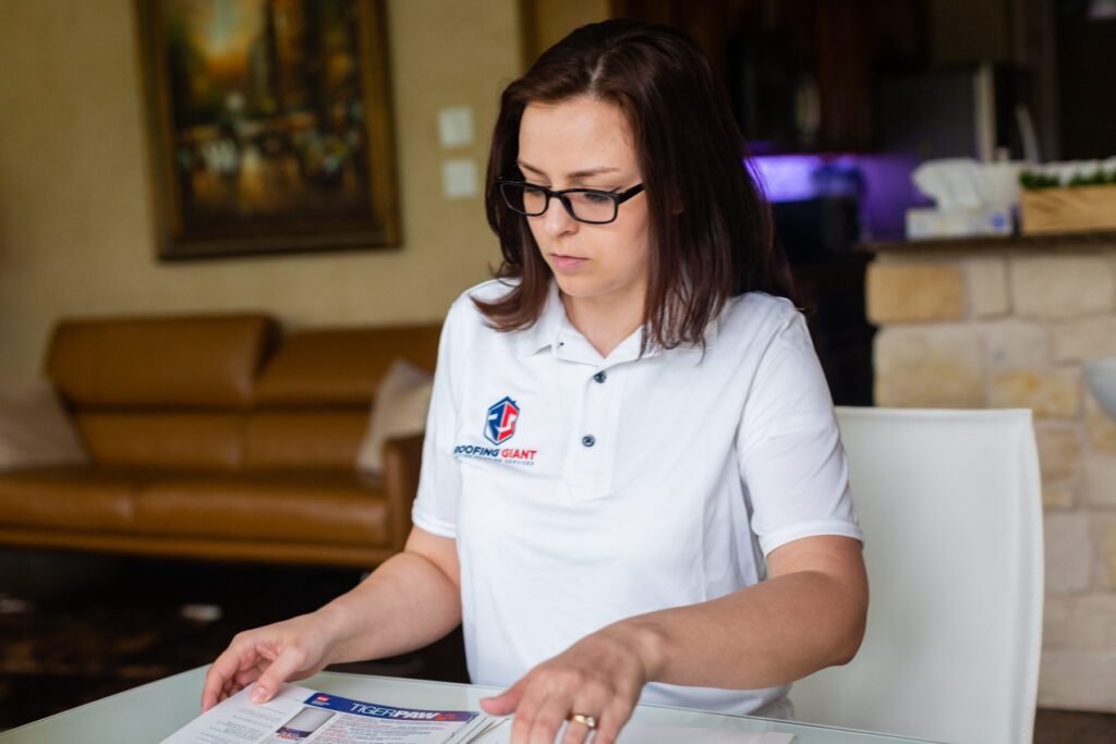 Roofing Giant specialist reviewing roof paperwork with a homeowner at the kitchen table