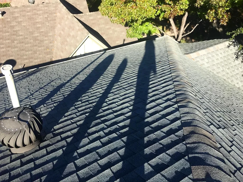 Existing roof ridge, vents and shingle covering before replacement.