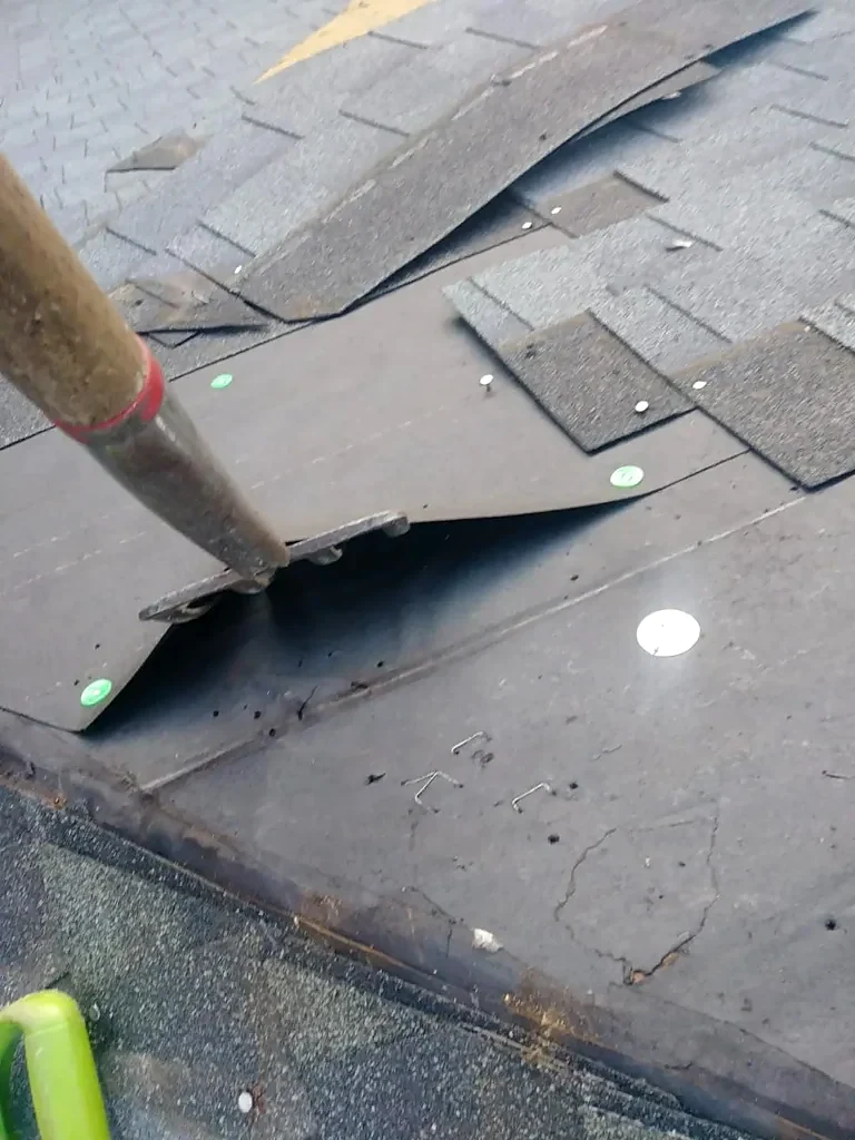 Old roofing being removed around a vent penetration.