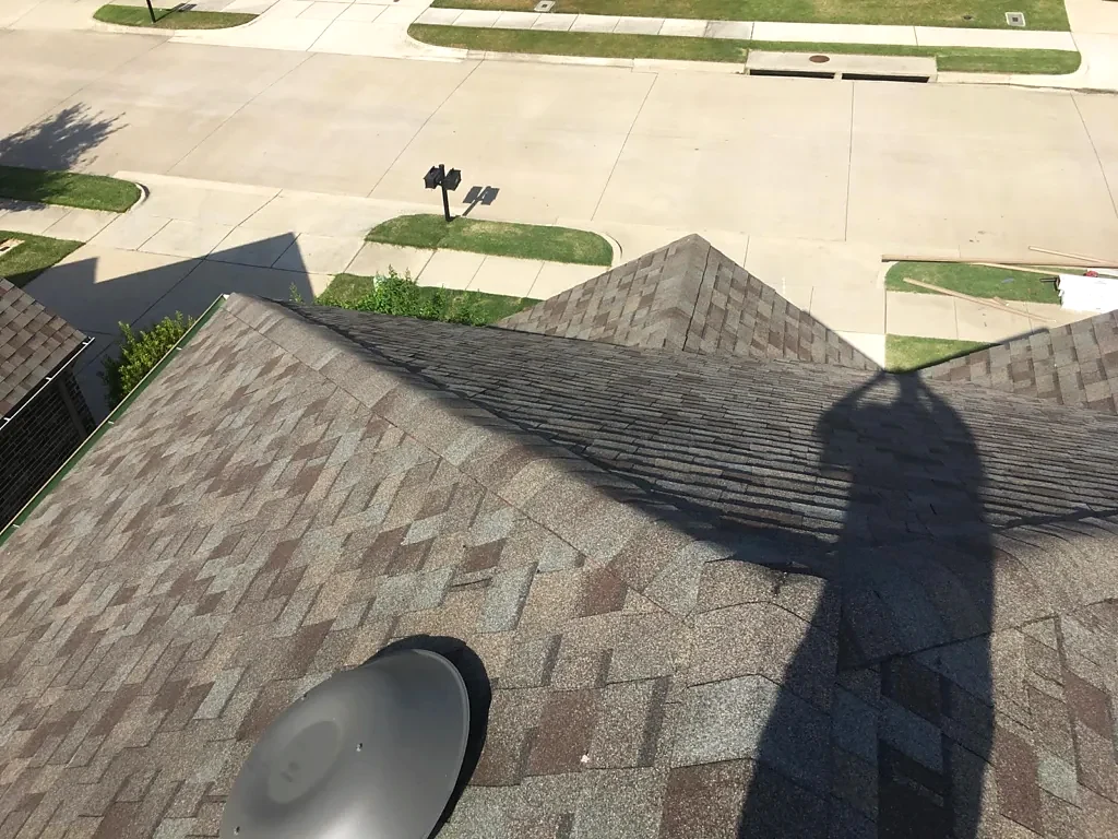 Installed shingles along a ridge and adjoining slopes.