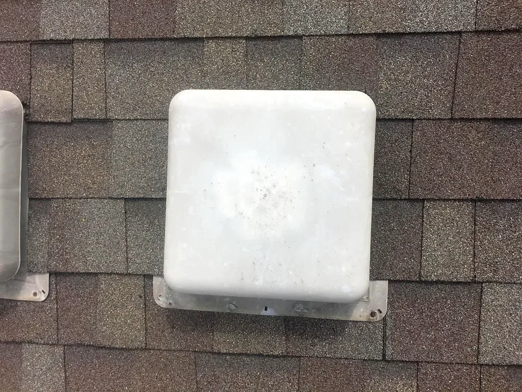 Low-profile vent and surrounding roof covering.