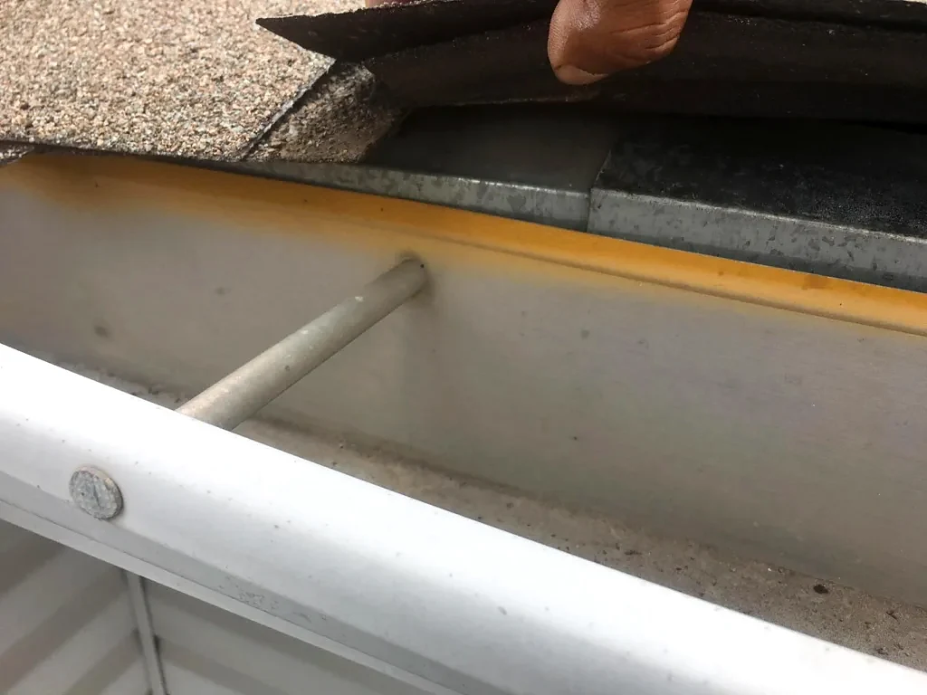 Roof edge and gutter inspected before replacement.