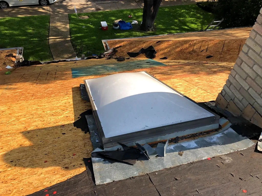 Skylight and exposed decking during roof replacement.