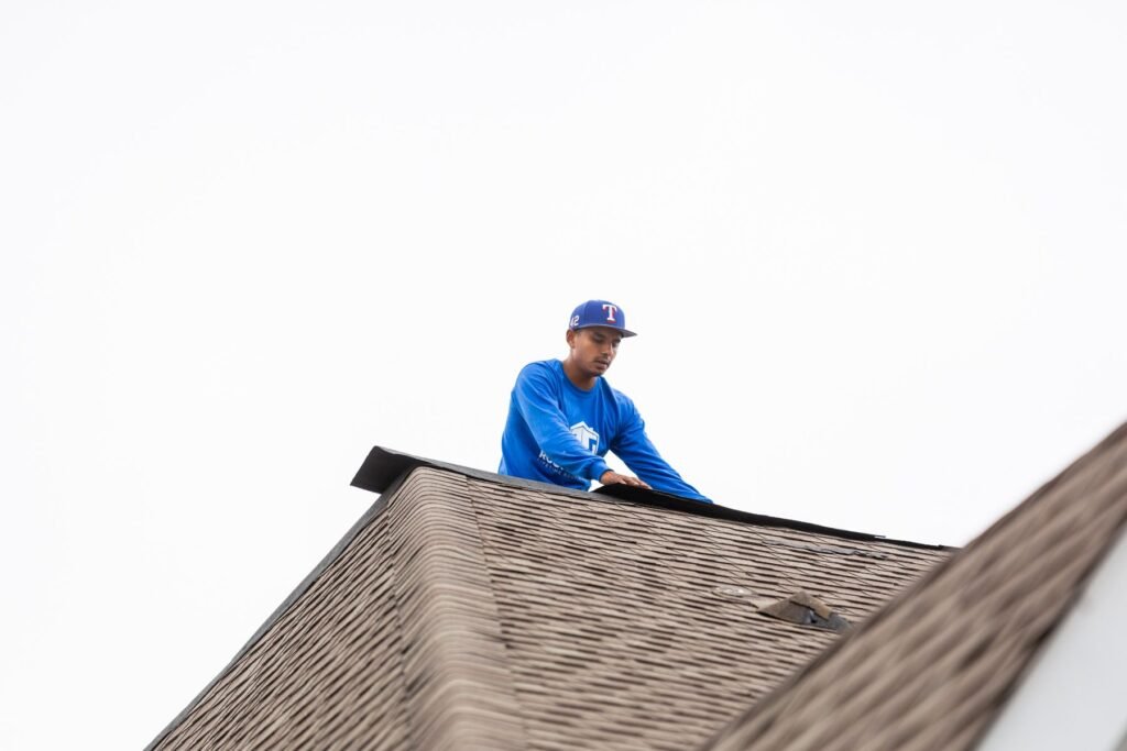 Roofing Giant roofer at the peak of a residential roof