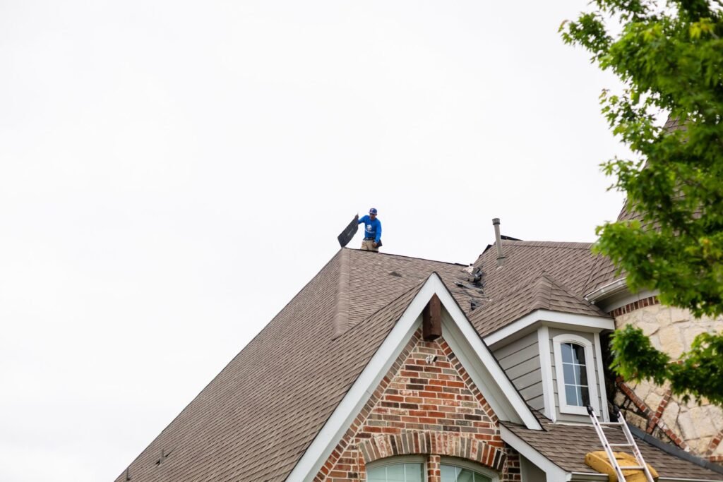 Roofing Giant crew on the roof of a brick home in the Dallas suburbs