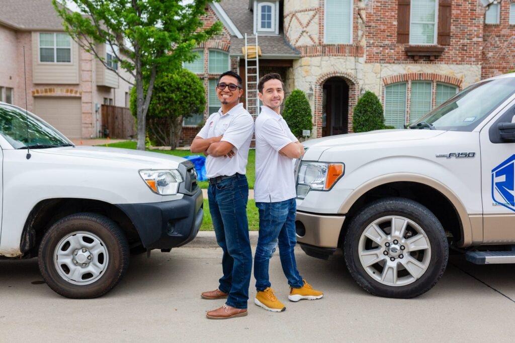 Roofing Giant team members standing beside the company truck