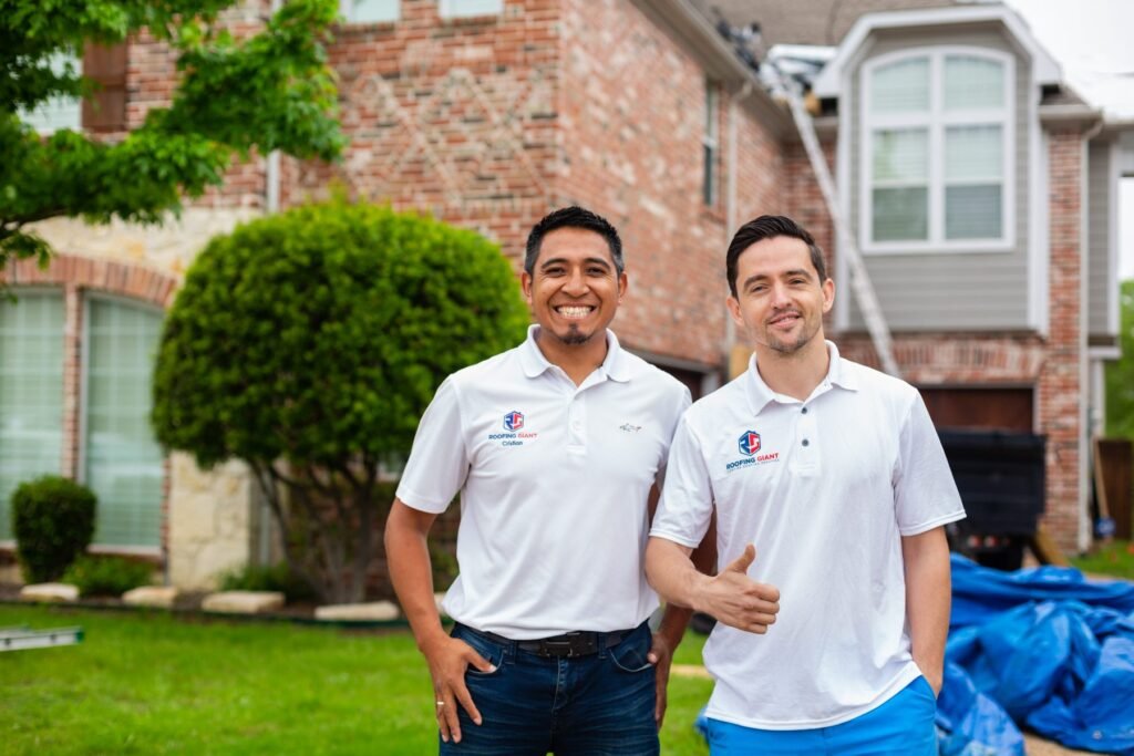 Two Roofing Giant team members in front of a brick home in the Dallas-Fort Worth area
