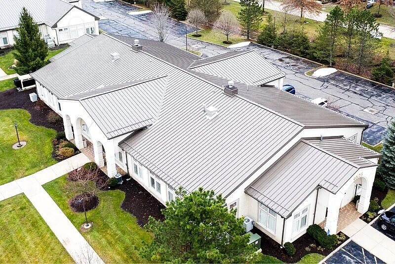 Real standing seam metal roof with raised vertical panel seams, photographed from above