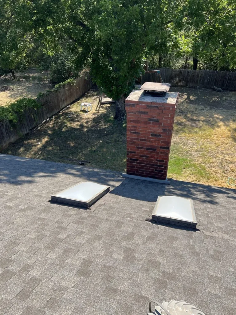 Roof shingles, two skylights and a brick chimney photographed during the North Richland Hills project inspection.
